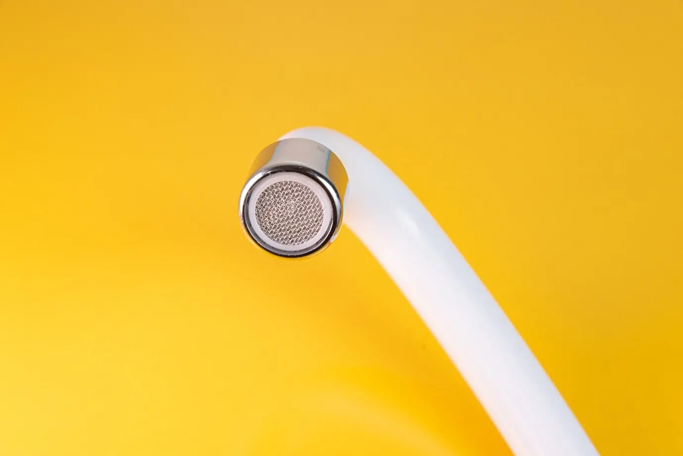 Close-up of a white kitchen sink faucet.